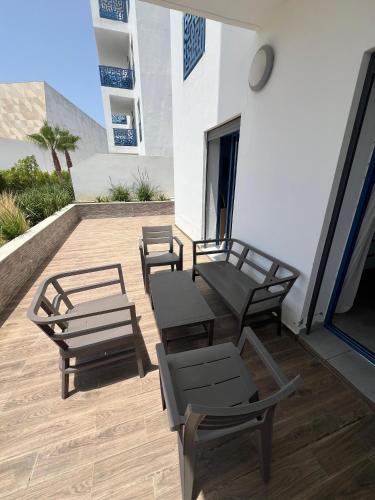 a patio with chairs and tables on a building at appartement costa mar martil avec piscine in Martil