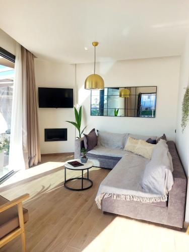 a living room with a couch and a table at Euphoria Seafront Residence in Anissaras