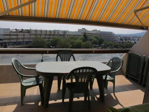 une table et des chaises sur un balcon avec vue dans l'établissement Studio Héliopolis E20 - 2 personnes, au Cap d'Agde