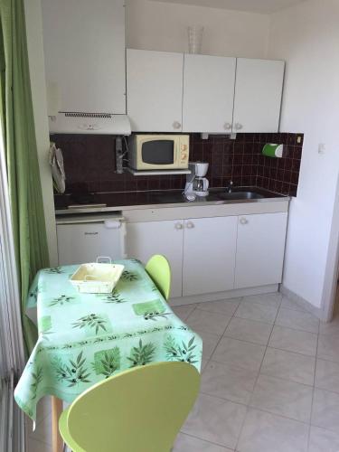 une petite cuisine avec une table et un micro-ondes dans l'établissement Studio Héliopolis E20 - 2 personnes, au Cap d'Agde