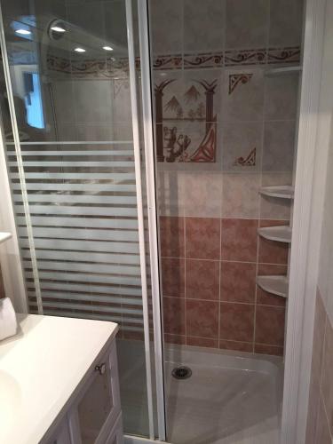 une douche avec une porte vitrée dans une salle de bain dans l'établissement Studio Héliopolis E20 - 2 personnes, au Cap d'Agde