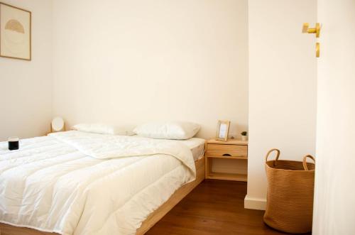 a bedroom with a white bed and a wooden floor at Memories by the Sea - Margarida do Mar in Costa da Caparica