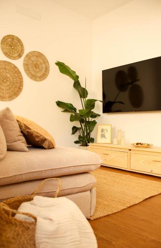 a living room with a couch and a flat screen tv at Memories by the Sea - Margarida do Mar in Costa da Caparica