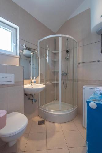 a bathroom with a shower and a toilet and a sink at APARTMENTS BRUNO 3 - two-room penthouse apartment - wonderful view of the sea - the best location, first row to the beach - 10 minutes from Supetar ferry port - free secured parking - facilities nearby in Sutivan