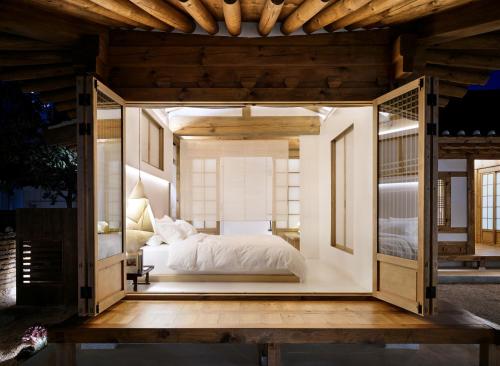 a bedroom with a bed in a glass house at Hyowudang in Gyeongju