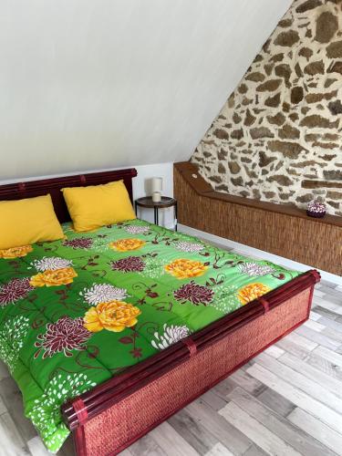 - un lit avec une couverture verte et des fleurs dans l'établissement Gîte indépendant renové à Neuf Saint Antoine 20 personnes, à Pleubian