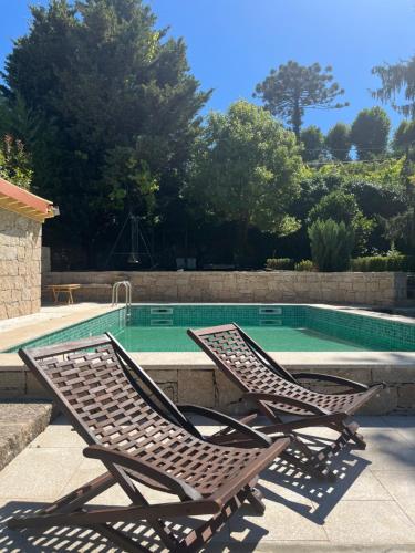 two lounge chairs sitting next to a swimming pool at Quinta De Fundevila -quinta privada in Cabeceiras de Basto