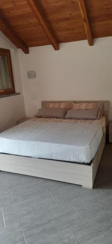 a bed in a bedroom with a wooden ceiling at La Tór Appartamenti - Pramotton in Donnas