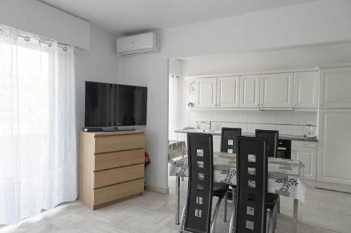 a kitchen with a table with chairs and a television at Appartement 2 pièces Cavalaire sur Mer 60m2 in Cavalaire-sur-Mer