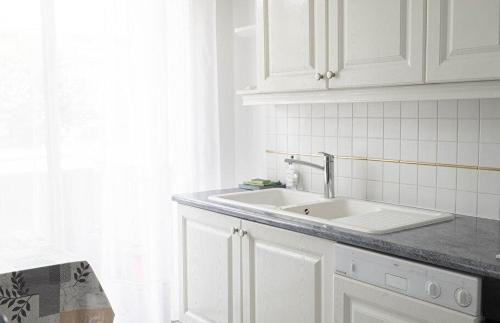 a white kitchen with a sink and a window at Appartement 2 pièces Cavalaire sur Mer 60m2 in Cavalaire-sur-Mer