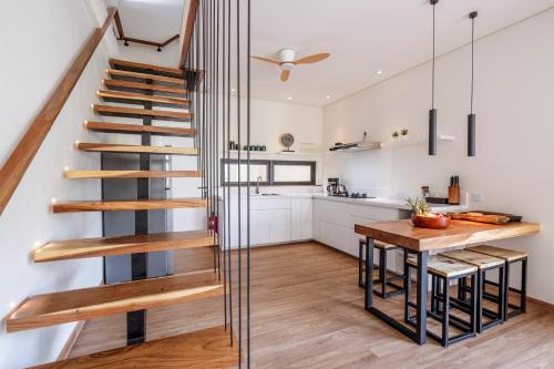 a kitchen with a spiral staircase and a dining room table at Oasis Residences in Sanur