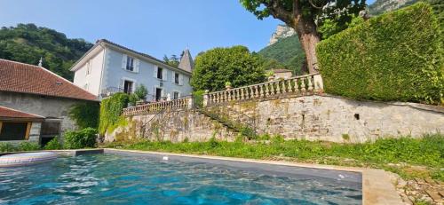 une piscine devant un mur avec une maison dans l'établissement Lovely family home in Chartreuse mountains, à Voreppe