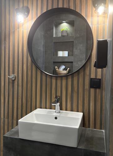a bathroom with a white sink and a mirror at StayInn Luxury Apartments in Nea Kalikratia