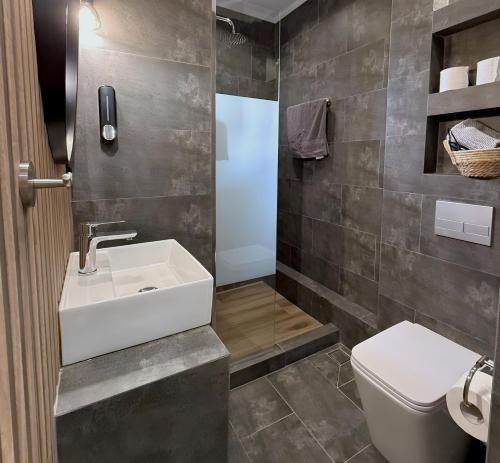 a bathroom with a sink and a toilet at StayInn Luxury Apartments in Nea Kalikratia
