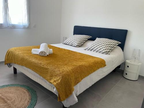 una camera da letto con un letto e un asciugamano sopra di Villa mitoyenne de standing proche de toutes commodités à Ghisonaccia a Ghisonaccia