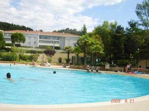 un groupe de personnes nageant dans une piscine dans l'établissement Appartement dans résidence avec piscines pour 5 personnes proximité Cannes, à Mougins