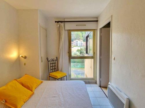 une chambre avec un lit et une grande fenêtre dans l'établissement Appartement dans résidence avec piscines pour 5 personnes proximité Cannes, à Mougins