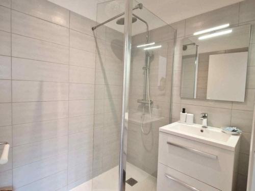 une salle de bain blanche avec une douche et un lavabo dans l'établissement Appartement dans résidence avec piscines pour 5 personnes proximité Cannes, à Mougins