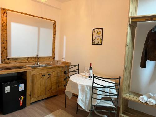 a kitchen with a table with a sink and a mirror at Pousada Saint Claire in Santo Antônio do Pinhal