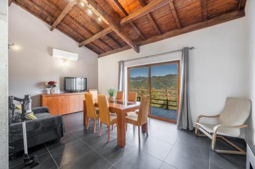 a living room with a table and chairs and a couch at Casa da raposeira in Louredo