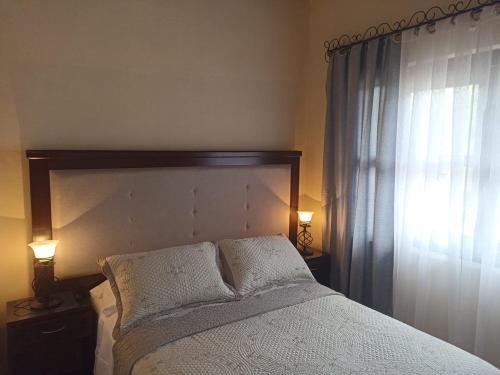 a bedroom with a bed with two pillows and a window at Cabaña la candela in Bernal