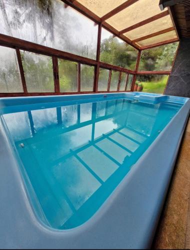 a large swimming pool in a building with a roof at Pousada Cantinho da Serra in Campos do Jordão