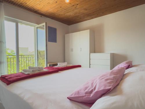 a bedroom with a large white bed with purple pillows at Rosemary Apartment in Promajna