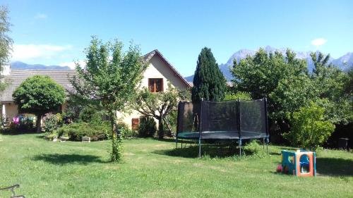 ein Haus mit einem Spielplatz im Hof in der Unterkunft Gîte de la Sézia in Quet-en-Beaumont