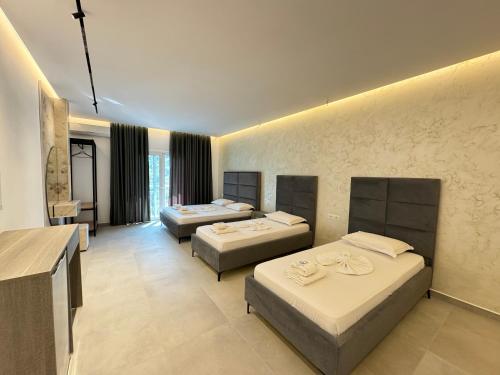a hotel room with three beds in it at Villa Bodini Himare in Himare