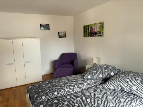 a bedroom with a bed and a purple chair at FeWo-Viktoria in Rheinau