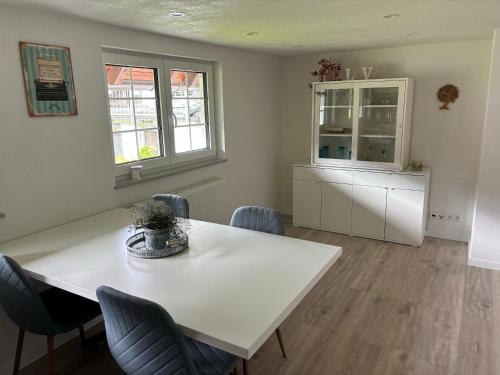 a dining room with a white table and chairs at FeWo-Viktoria in Rheinau