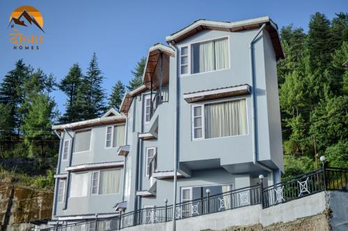a large white building with a balcony at दोgri Homes in Kīar