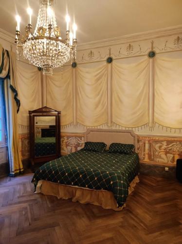 une chambre avec un lit et un lustre dans l'établissement Château de Crépol, 