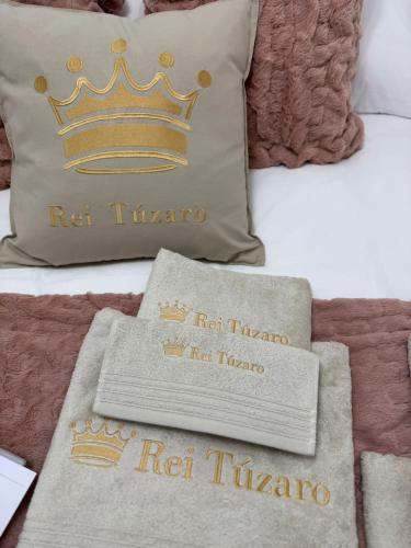 a bed with a pillow with a crown on it at Rei Túzaro in Milladoiro