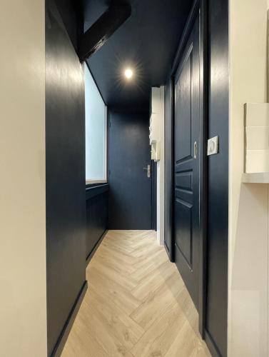 - un couloir avec des murs noirs et du parquet dans l'établissement 2 pièces Pau centre-ville, à Pau