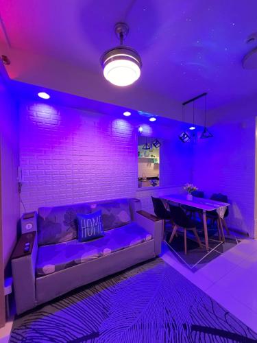a purple room with a couch and a table at TAGAYTAY CONDO STAY BY RL's SUITE in Tagaytay