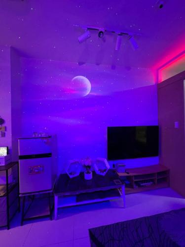 a purple room with a tv and a moon on the ceiling at TAGAYTAY CONDO STAY BY RL's SUITE in Tagaytay