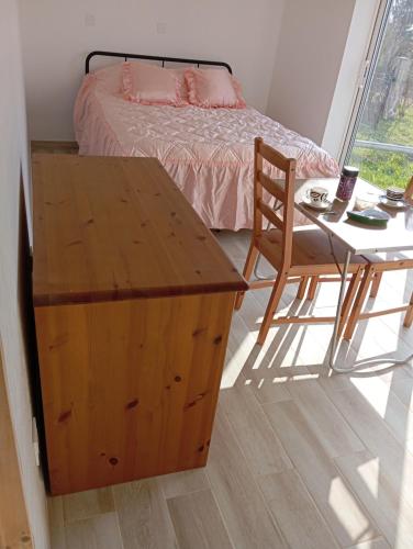 une chambre avec un lit, une table et une chaise dans l'établissement Chez Lou et Amour, à Luché-Pringé