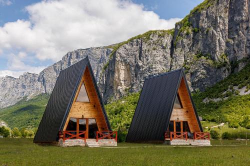 Dos pequeñas casas frente a una montaña en Silence House, en Šavnik