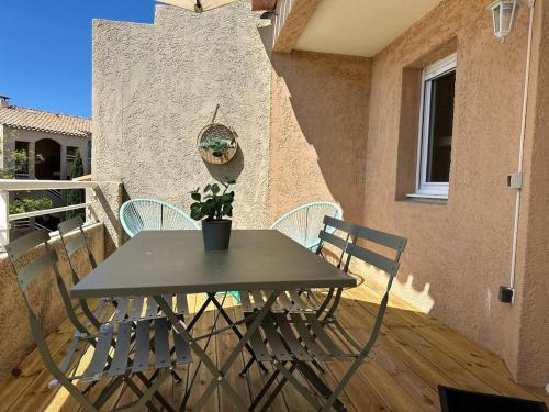 d'une table et de chaises sur un balcon avec une plante. dans l'établissement FIDJI - Studio vue sur mer avec piscine, à Sausset-les-Pins