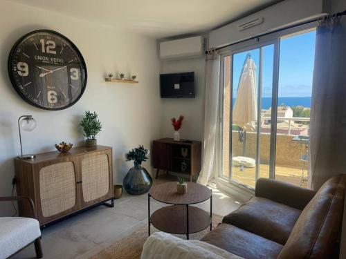 - un salon avec une grande horloge murale dans l'établissement FIDJI - Studio vue sur mer avec piscine, à Sausset-les-Pins