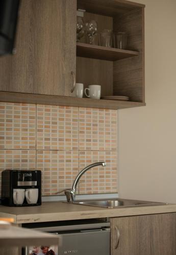 a kitchen with a sink and a counter top at StayInn Luxury Apartments in Nea Kalikratia