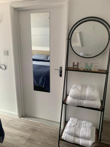 a room with a mirror and a shelf with towels at St Faith's Chambers in Maidstone