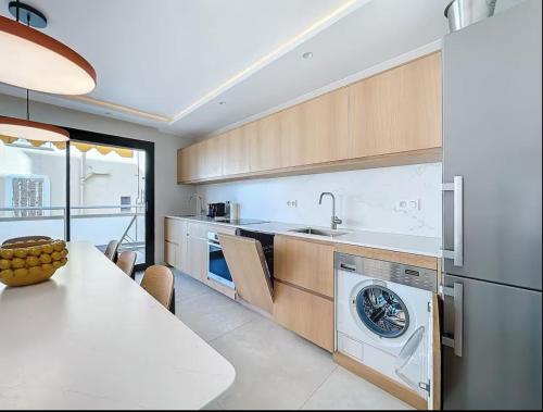 une cuisine avec une machine à laver et une table dans l'établissement Le Royal Croisette, à Cannes