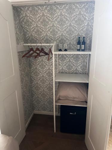 a small closet with a shelf with bottles and glasses at The Cotton Suites B&B in Deerlijk