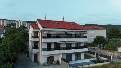 a white building with a red roof at Rijeka Relax Apartment with parking in Rijeka