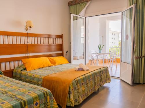 a hotel room with two beds and a balcony at Hotel Montana by Bossh! Hotels in Roses