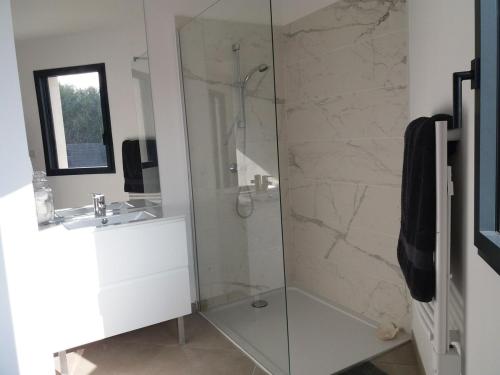 une salle de bain avec une douche en verre et un lavabo dans l'établissement villa moderne au centre de l'Isle sur la Sorgue, à LʼIsle-sur-la-Sorgue