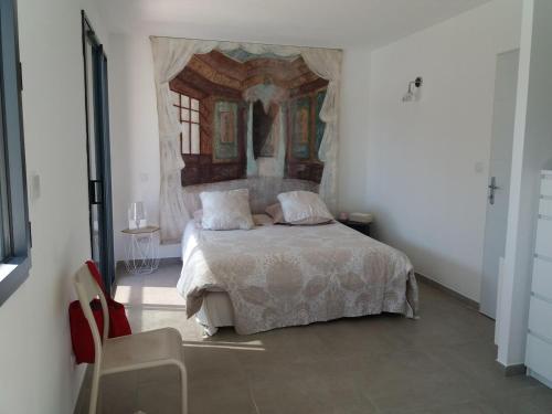 une chambre avec un lit avec un tableau sur le mur dans l'établissement villa moderne au centre de l'Isle sur la Sorgue, à LʼIsle-sur-la-Sorgue