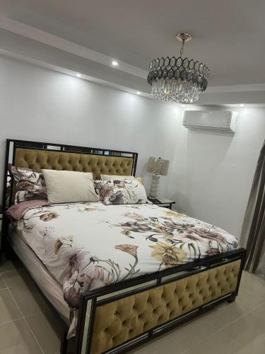 a bedroom with a bed and a chandelier at Residencial Pancho III in Los Mameyes